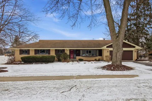 a front view of a house with a yard covered in snow