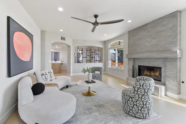 a living room with furniture a clock and a chandelier