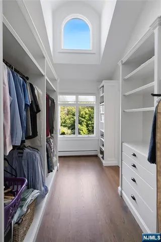 a view of walk in closet with clothes and shoes