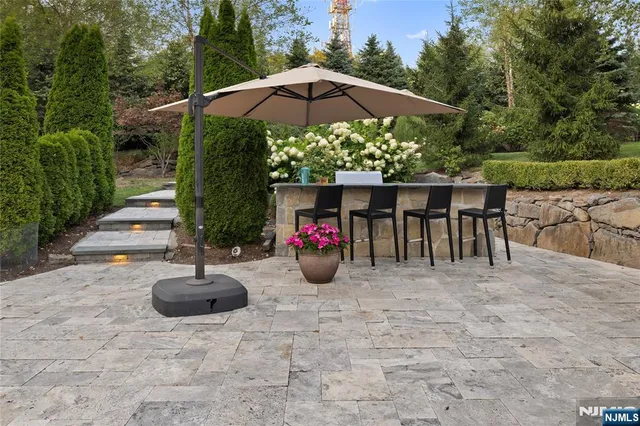 a view of a patio with table and chairs under an umbrella