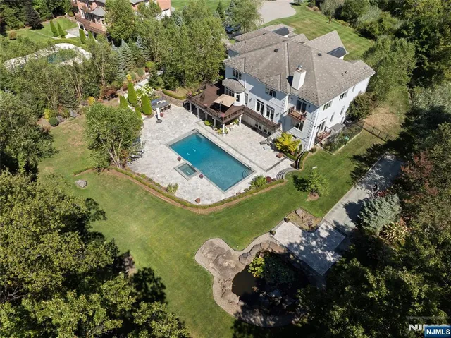an aerial view of a house with a yard and swimming pool