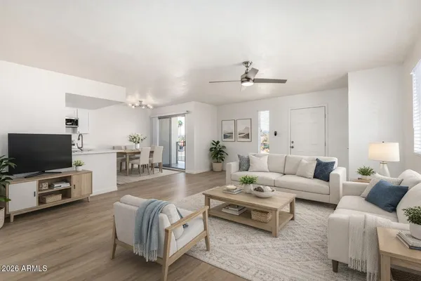 a living room with furniture a flat screen tv and kitchen view