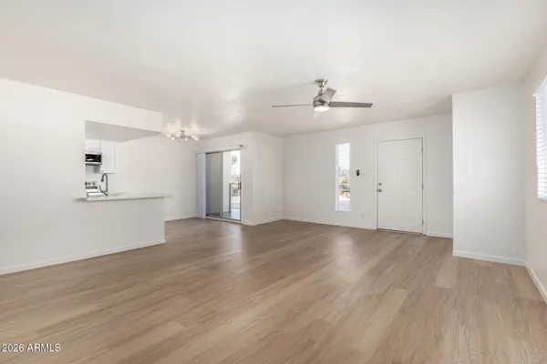 an empty room with wooden floor and windows
