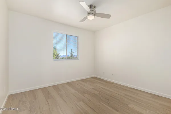 an empty room with a window and ceiling fan