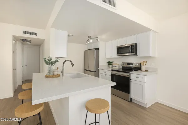 a kitchen with stainless steel appliances a stove a sink a microwave and a refrigerator