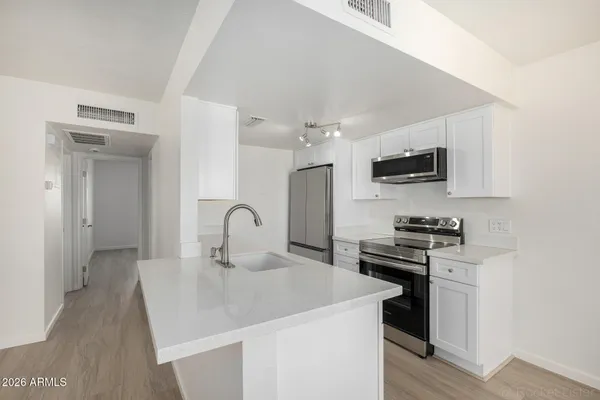 a kitchen with stainless steel appliances a sink stove and refrigerator