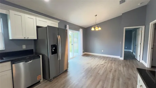 a kitchen with granite countertop a refrigerator and a stove top oven