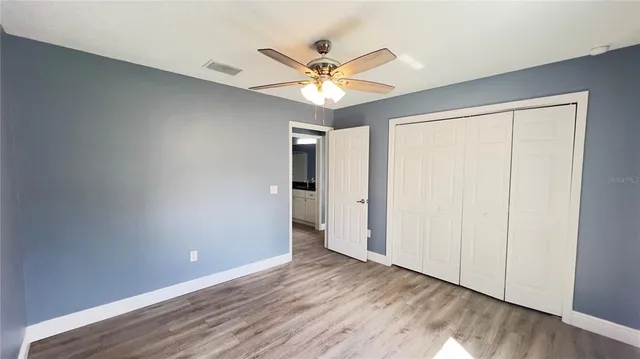 a view of a livingroom with a ceiling fan and wooden floor