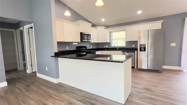 a kitchen with a refrigerator a sink and a microwave