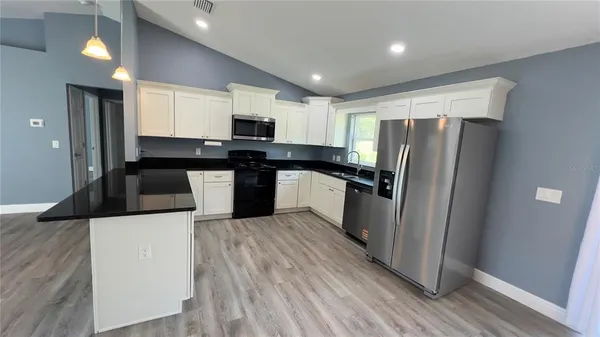 a kitchen with stainless steel appliances a refrigerator and a stove top oven