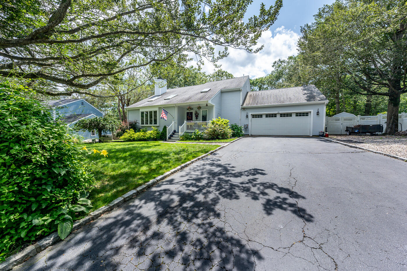 23 Redwood Circle Mashpee, MA 02649 - Photo 2 of 40 a front view of a house with a garden and trees