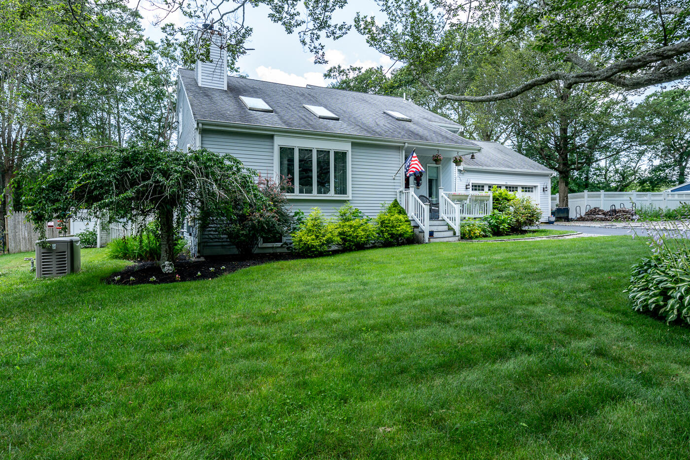 23 Redwood Circle Mashpee, MA 02649 - Photo 4 of 40 a front view of a house with a garden and trees