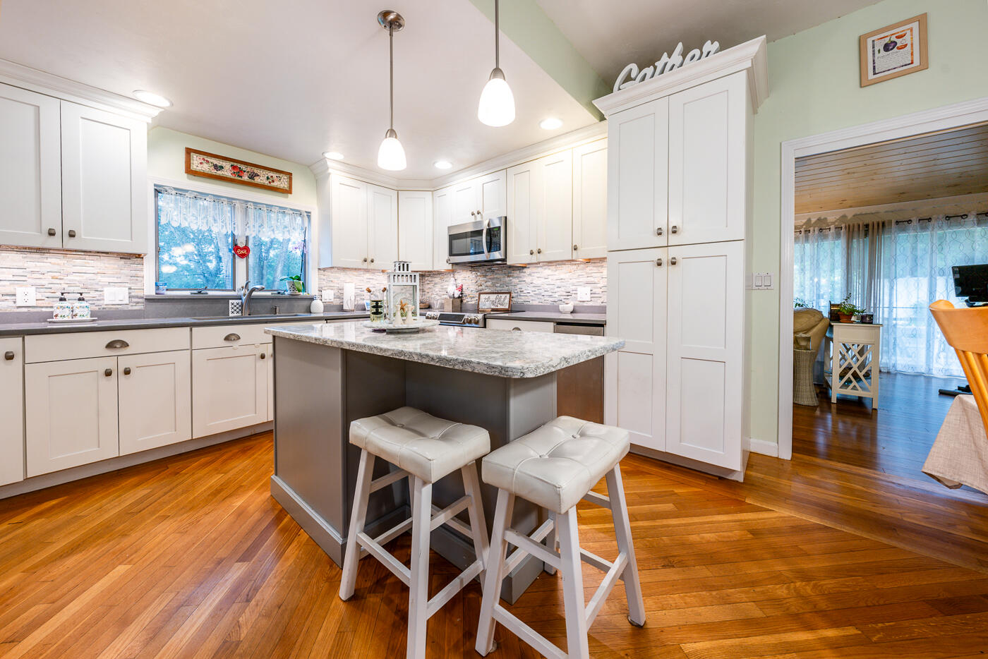23 Redwood Circle Mashpee, MA 02649 - Photo 10 of 40 a kitchen with stainless steel appliances a dining table chairs sink and cabinets