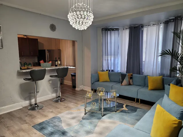 a living room with furniture a chandelier and a window