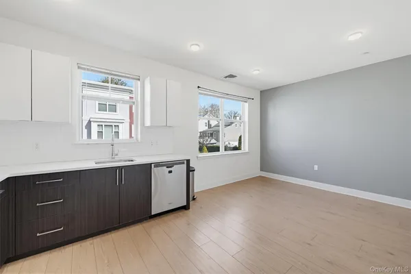 a large kitchen with stainless steel appliances granite countertop a large window