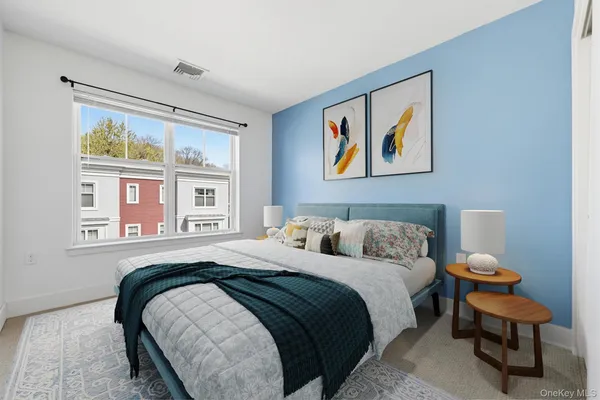 a bedroom with a bed and a painting on the wall