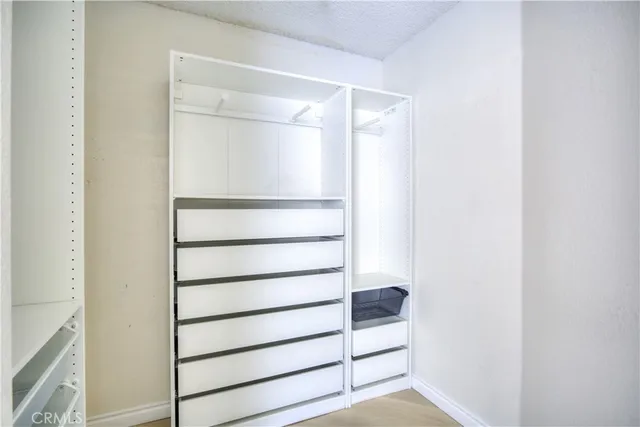 a view of walk in closet with empty racks