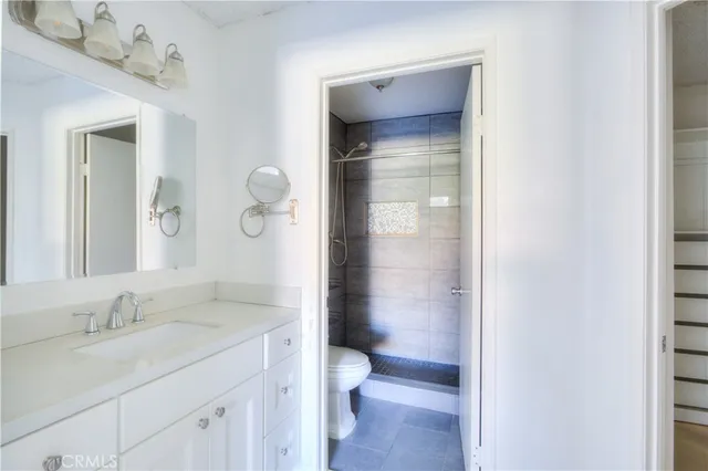 a bathroom with a granite countertop sink toilet and shower