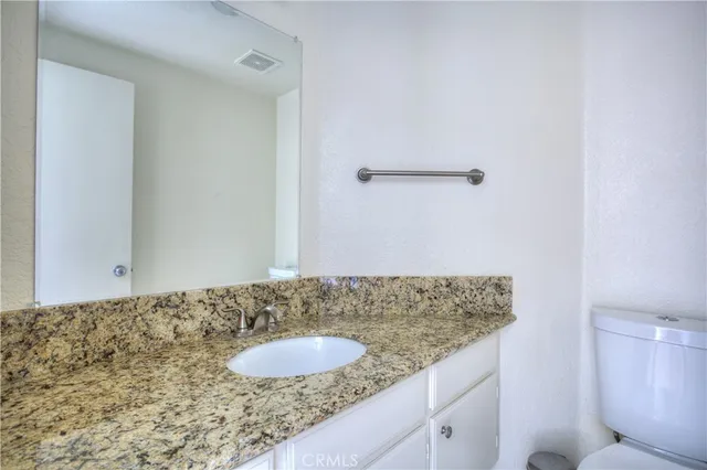 a bathroom with a granite countertop sink and a mirror