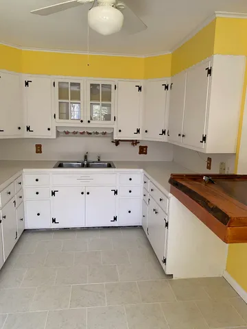 a view of cabinets with stainless steel appliances wooden floor and view living room