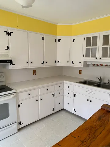 a kitchen with white cabinets and white appliances
