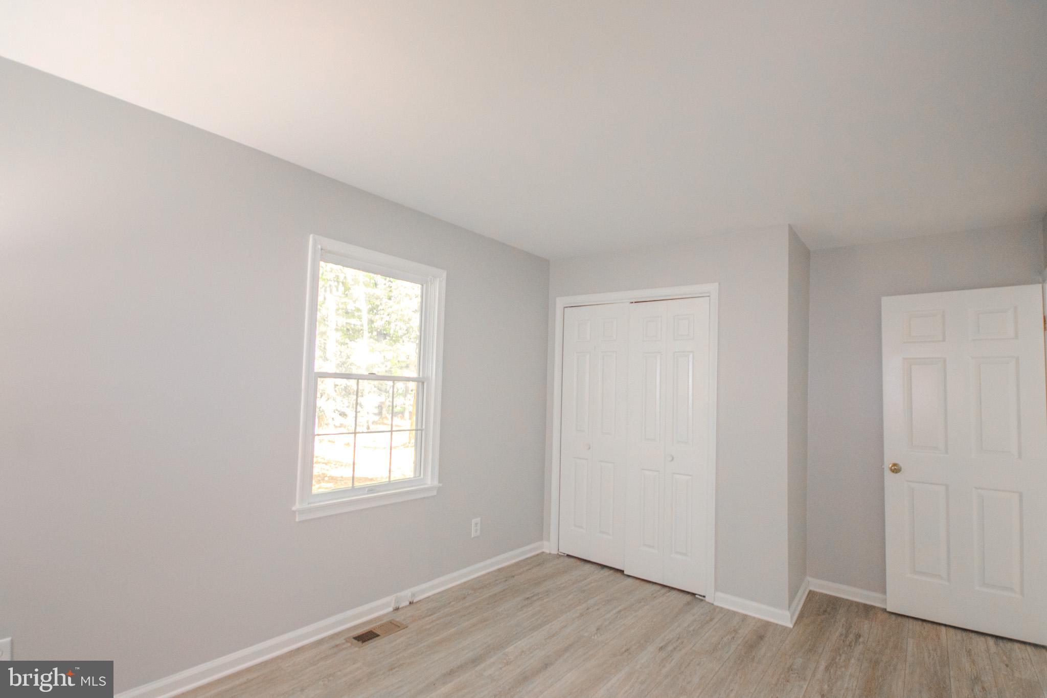 103 Ocean Parkway Ocean Pines, MD 21811 - Photo 13 of 44 an empty room with wooden floor and windows