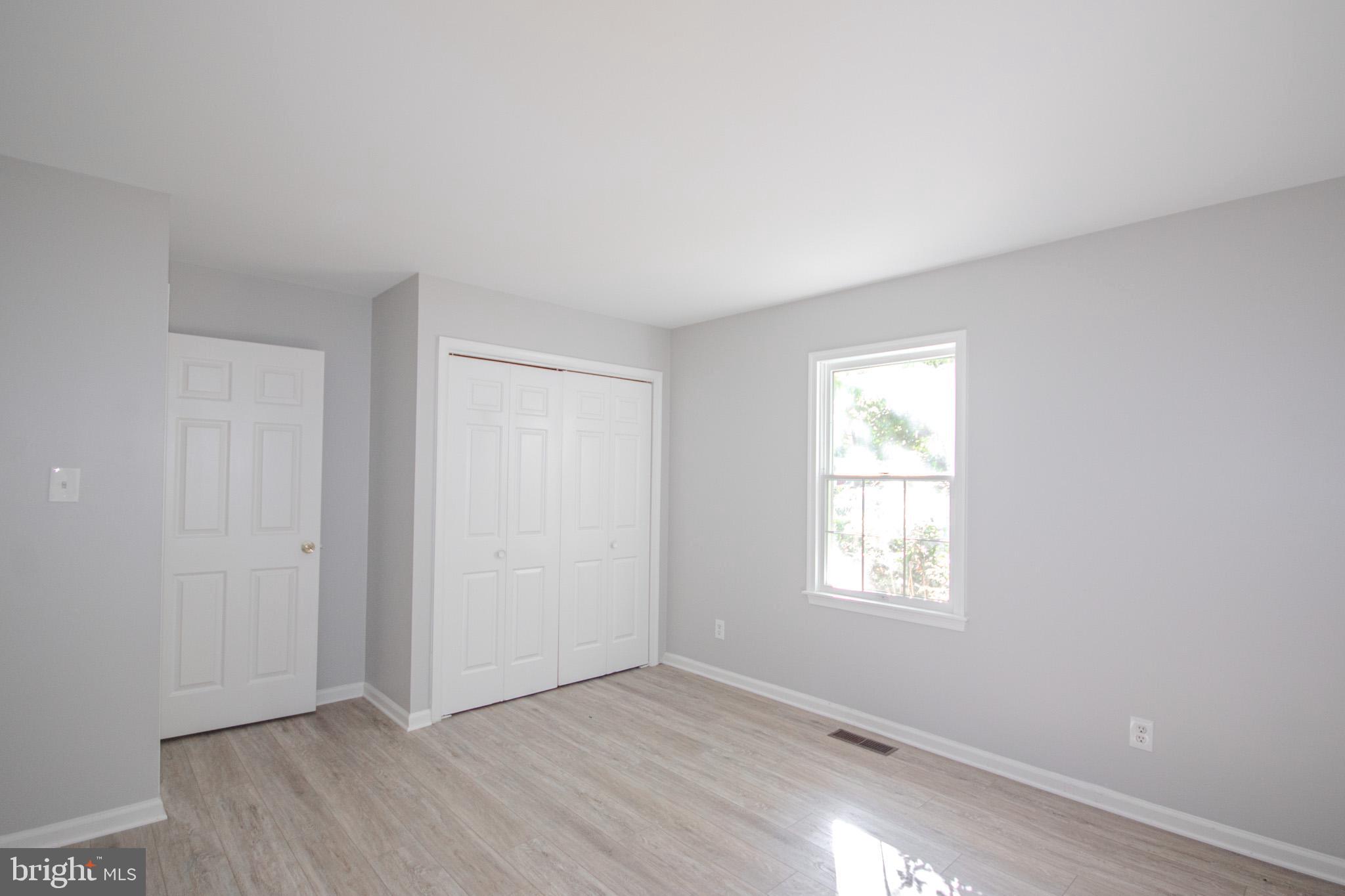 103 Ocean Parkway Ocean Pines, MD 21811 - Photo 17 of 44 an empty room with wooden floor and windows