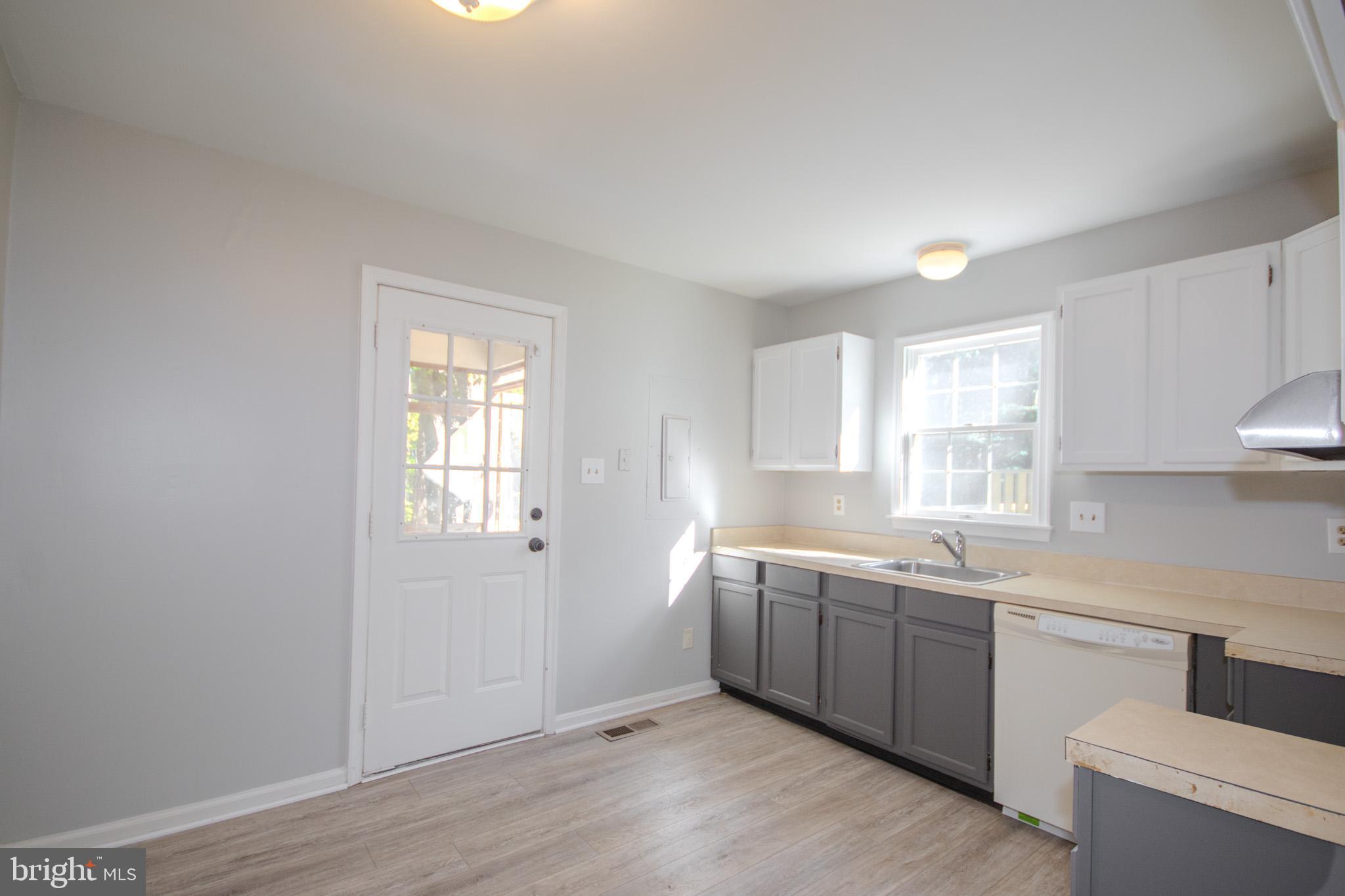 103 Ocean Parkway Ocean Pines, MD 21811 - Photo 9 of 44 a large white kitchen with a sink a window and cabinets