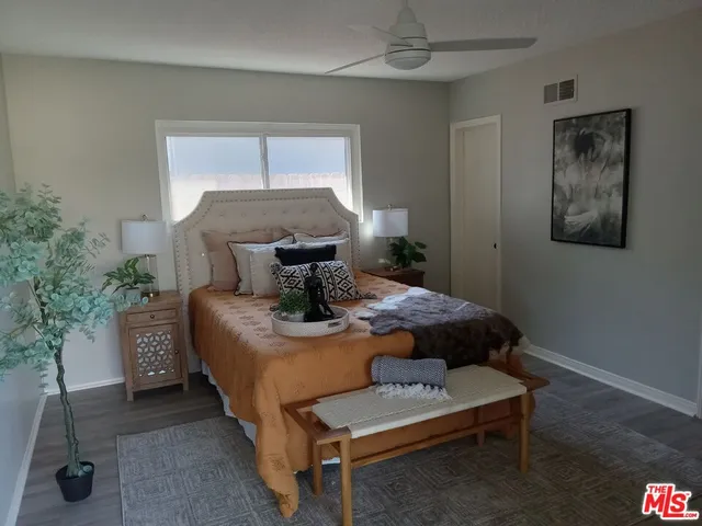 a bedroom with a bed and a potted plant