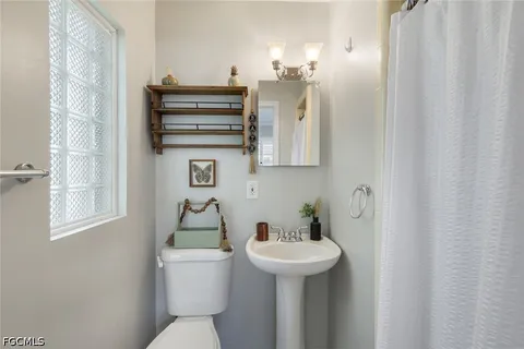 a bathroom with a sink and mirror with toilet