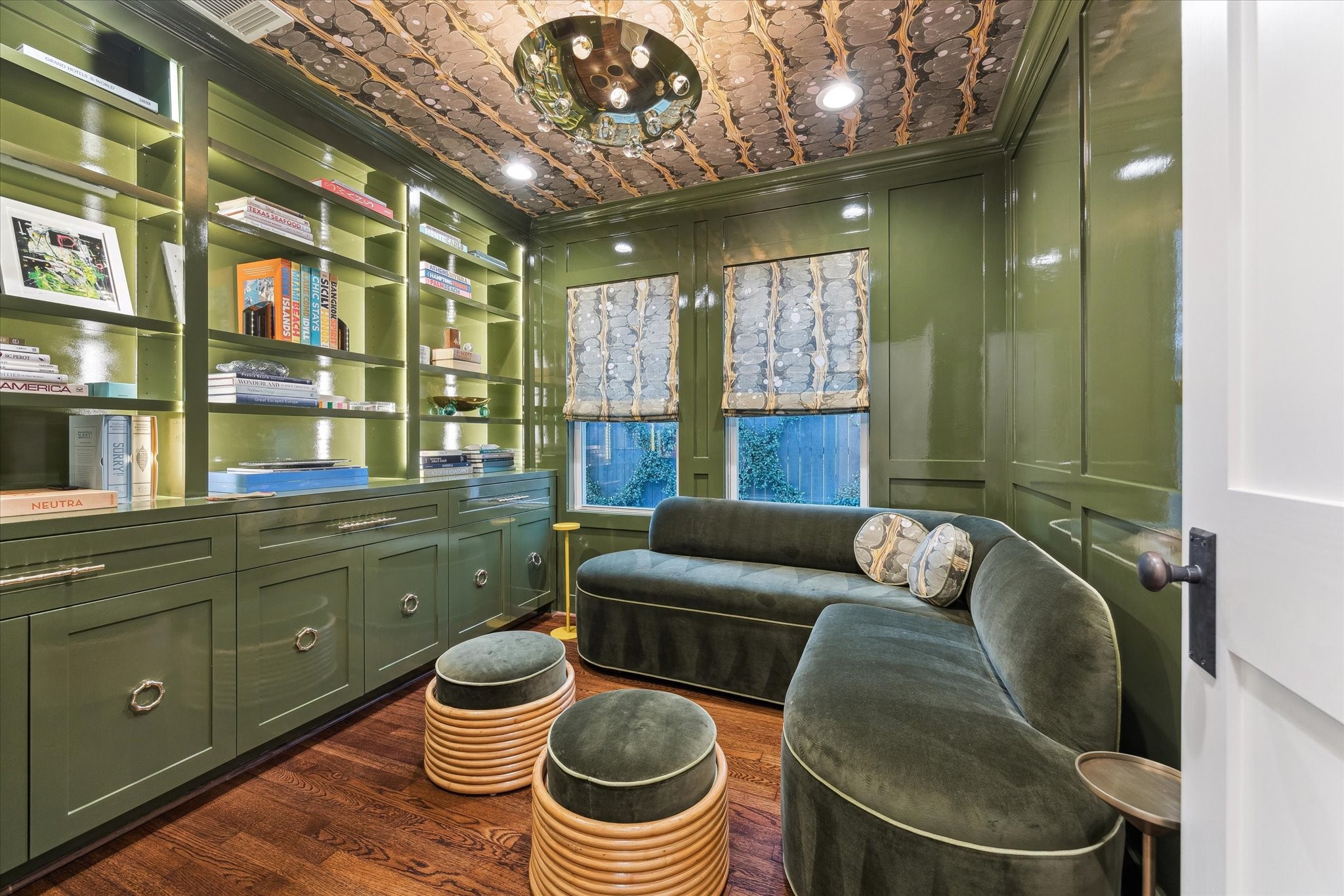 2124 Sul Ross Street Houston, TX 77098 - Photo 16 of 36 Middle bedroom on first floor has been transformed into a lounge space with built in shelving and cabinetry, custom window shades, Voutsa wallpaper on ceiling, strip lighting throughout and Farrow & Ball lacquer paint.