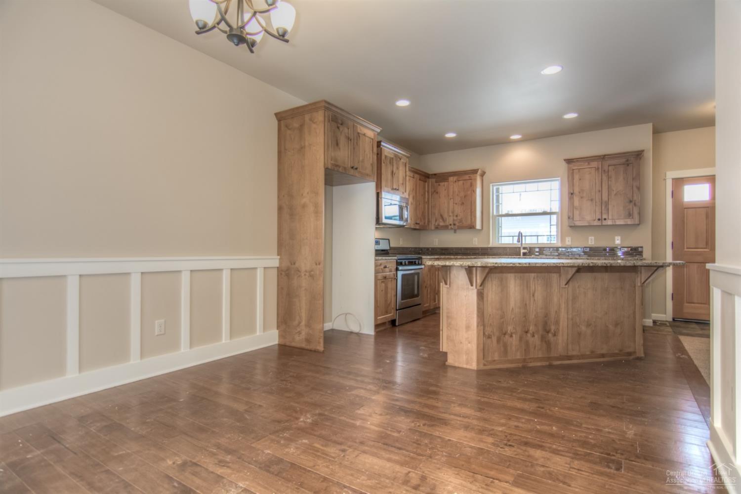 62720 Hawkview Road Bend, OR 97701 - Photo 2 of 16 a kitchen with stainless steel appliances granite countertop a stove top oven a sink and a microwave