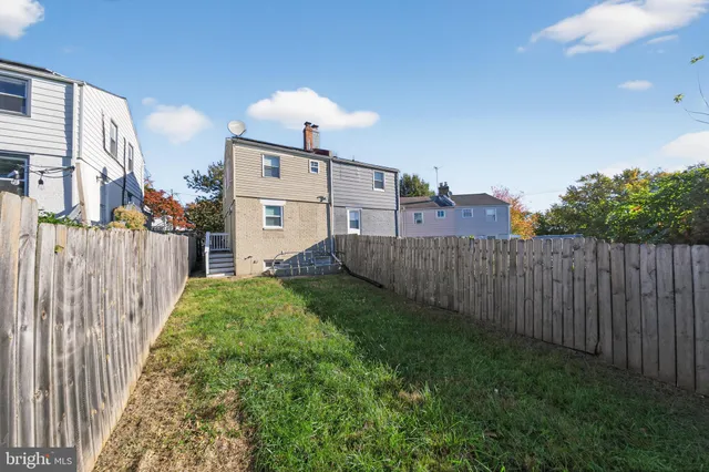 a view of a backyard with wooden fence