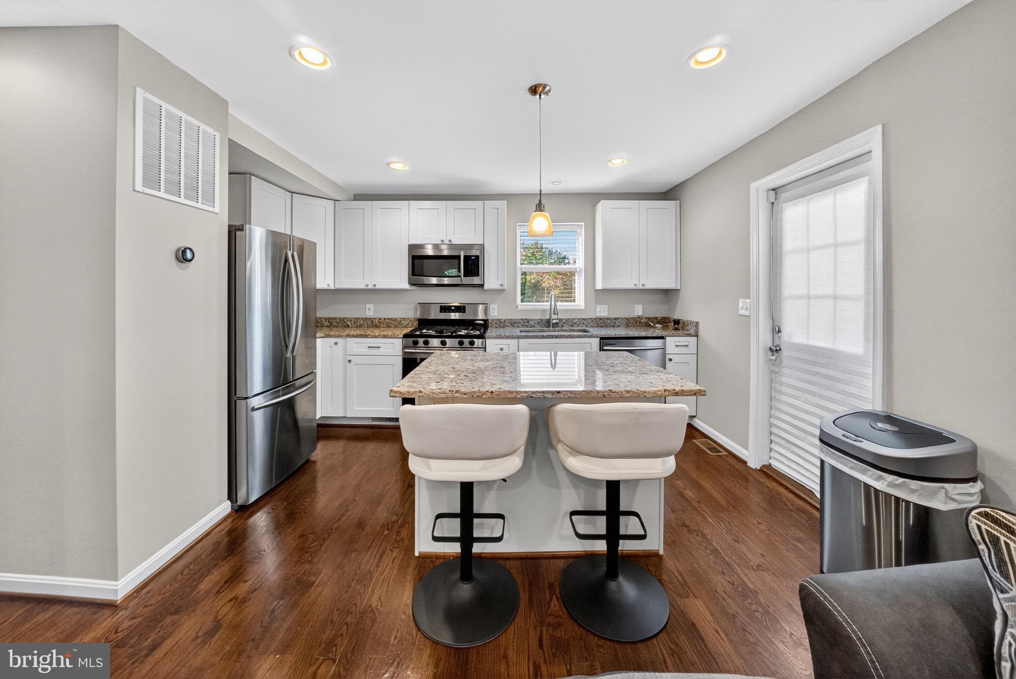 5211 Jay Street Northeast Washington, DC 20019 - Photo 5 of 17 a kitchen with kitchen island granite countertop a sink cabinets and stainless steel appliances