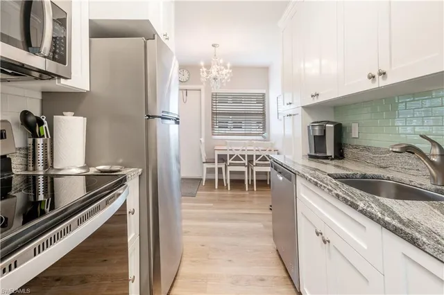 a kitchen with stainless steel appliances granite countertop a refrigerator and a sink