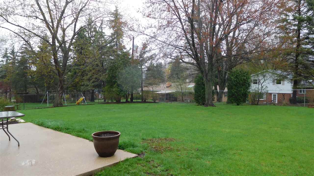 4874 Braewild Road Rockford, IL 61107 - Photo 20 of 23 a view of a backyard with huge green area and large trees