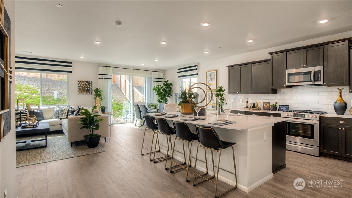 1017 Panoramic Loop, Unit 95 Bremerton, WA 98312 - Photo 6 of 14 a living room with stainless steel appliances granite countertop a sink dishwasher a stove and a refrigerator with wooden floor