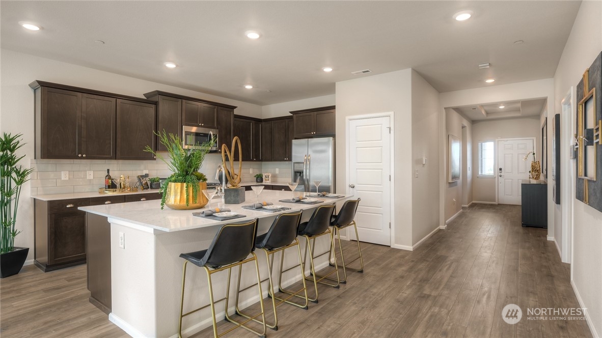 1017 Panoramic Loop, Unit 95 Bremerton, WA 98312 - Photo 8 of 14 a kitchen with stainless steel appliances kitchen island granite countertop a stove a refrigerator a sink a dining table and chairs