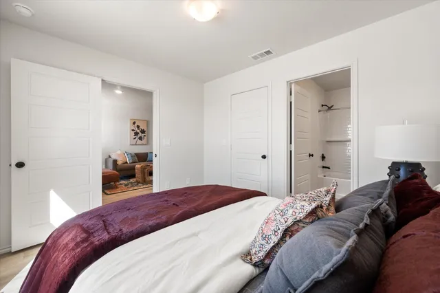 a bedroom with a bed and wooden floor