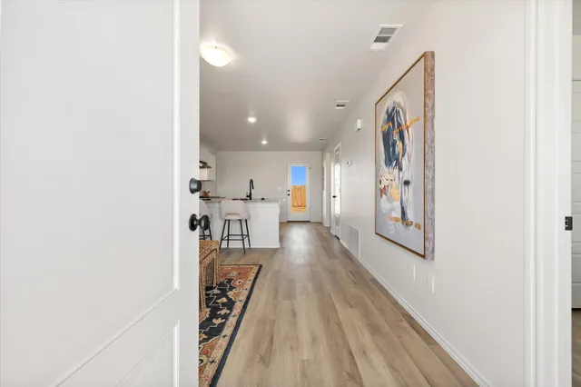 a view of a hallway with wooden floor