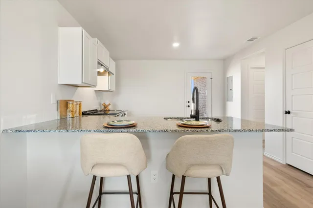 a kitchen with stainless steel appliances granite countertop a sink and a refrigerator