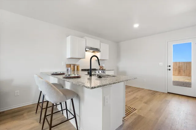 a kitchen with a sink cabinets and wooden floor