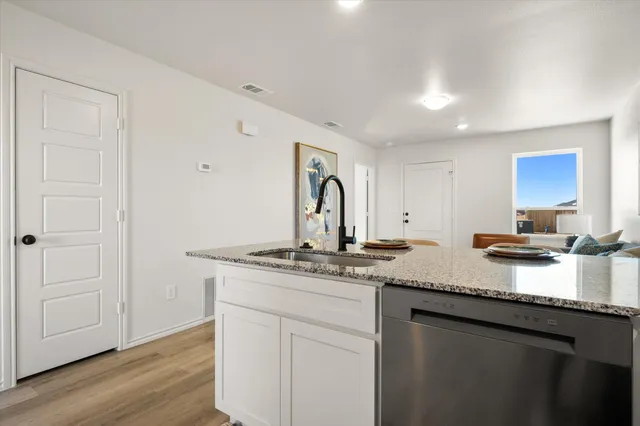 a kitchen with stainless steel appliances granite countertop a sink stove and cabinets