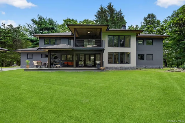 a front view of a house with balcony and outdoor seating