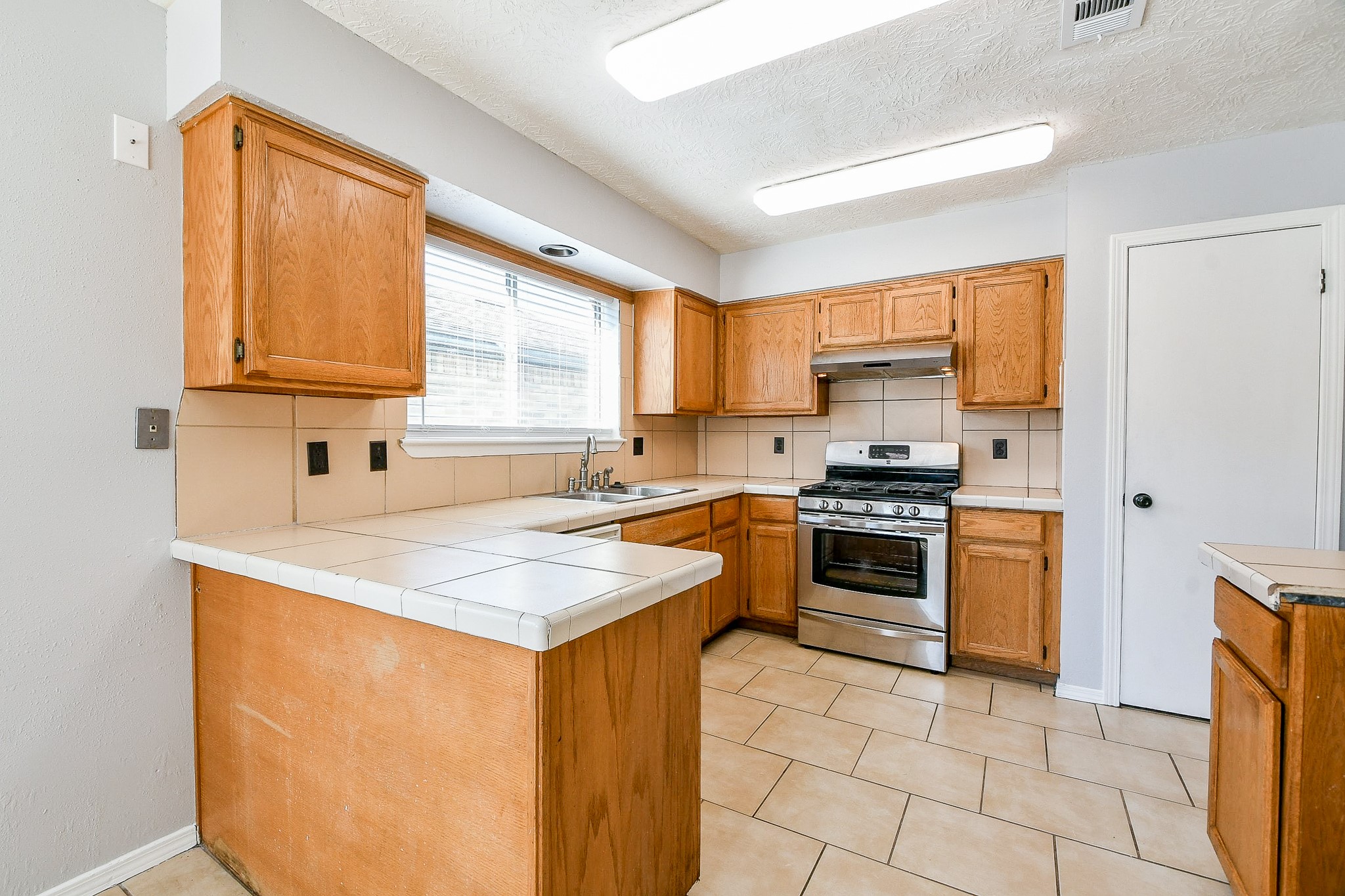 4719 Brownfields Drive Houston, TX 77066 - Photo 11 of 20 a kitchen with a stove a sink and a refrigerator