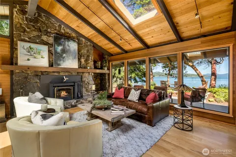 a living room with furniture large windows with wooden floor