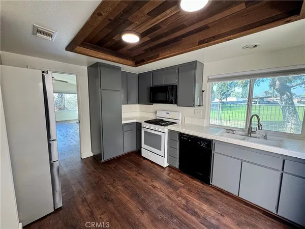 a kitchen with stainless steel appliances kitchen island granite countertop a stove a sink and a refrigerator