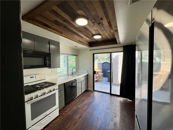 a kitchen with stainless steel appliances granite countertop a large stove a sink dishwasher and a refrigerator with wooden floor
