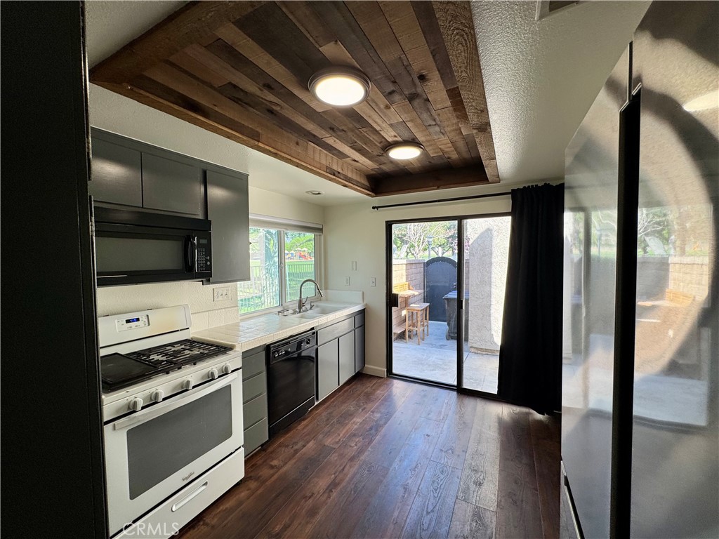 9801 Allesandro Court Rancho Cucamonga, CA 91730 - Photo 7 of 21 a kitchen with stainless steel appliances granite countertop a large stove a sink dishwasher and a refrigerator with wooden floor