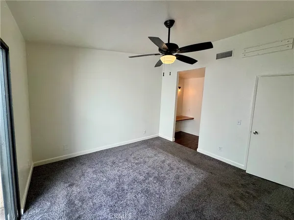 an empty room with a window and a fan